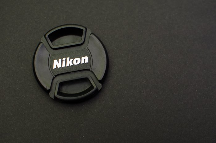 Крышка объектива Nikon на сером фоне - как использовать серую карту для баланса цветов