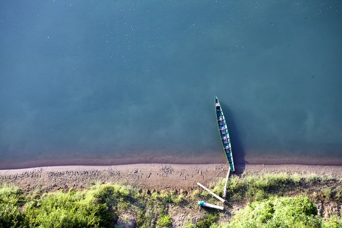 Вид с воздуха на небольшую лодку в прибрежном минималистском пейзаже