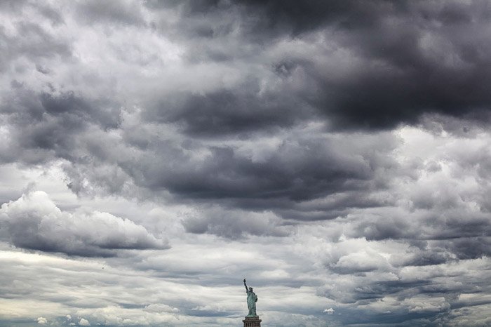 The statue of liberty under a cloudy sky - minimal landscape photography 