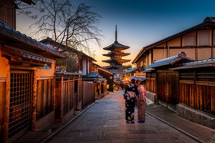 Портрет двух людей, стоящих у впечатляющего храма в Киото на закате - фотографии Японии