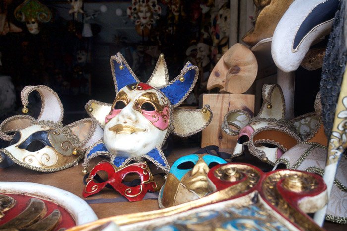 Коллекция венецианских праздничных масок в витрине магазина - лучшие советы по фотографированию Венеции
