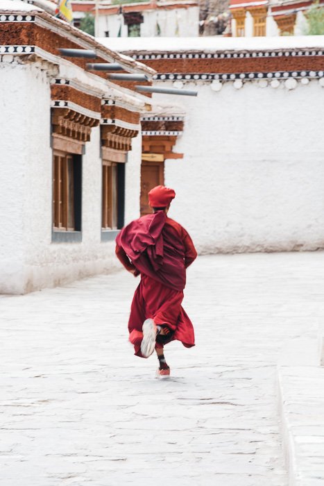 Решающий момент молодого монаха, бегущего по улице в Ладакхе