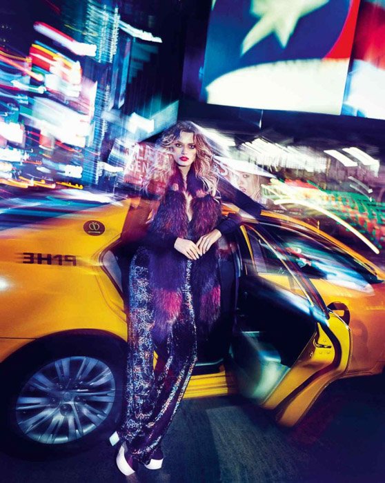 Поразительный портрет женской модели, позирующей у такси - ночная модная фотография на улице