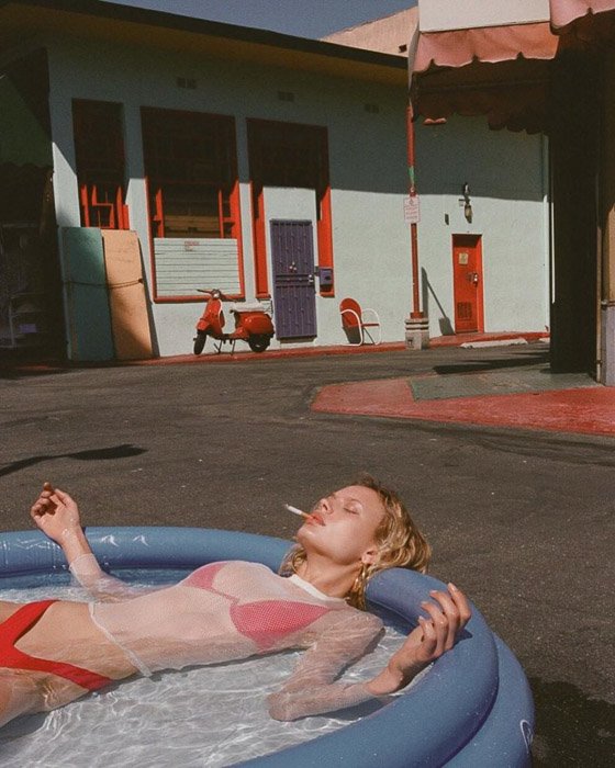 A blonde fashion model in the plastic swimming pool smoking a cigarette by v - fashion photography inspiration