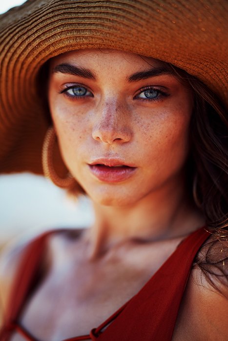 A stunning portrait of a female model in the sunhat - female face portrait