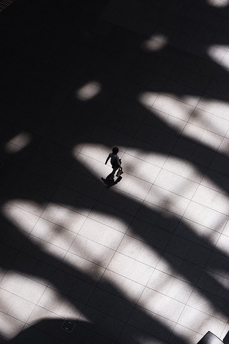 Аэрофотоснимок человека, идущего среди тяжелых теней по каменной дорожке - форменная фотография