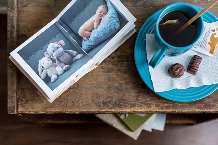 A coffee table flat lay featuring a baby book and cup of tea