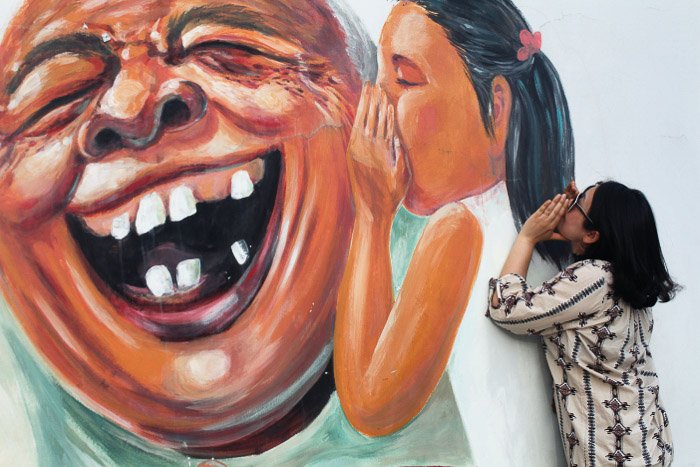 Городской портрет женской модели, позирующей у настенного граффити