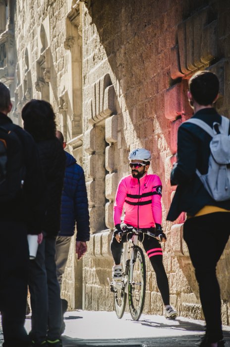 Вид улицы на людей с акцентом на байкера в розовой куртке