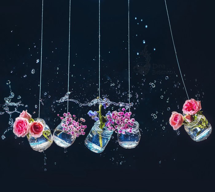Креативный цветочный тематический натюрморт из цветов в стеклянных банках, снятый со спидлайтом
