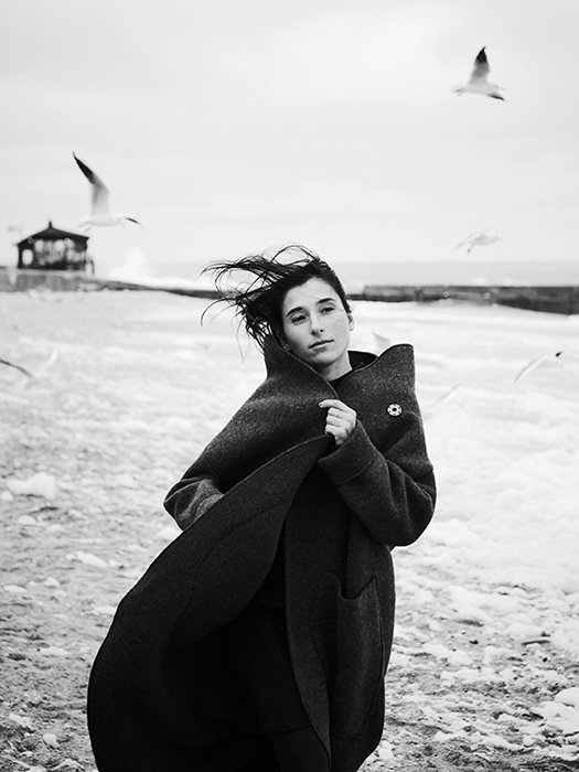 Однотонный портрет женщины-модели, идущей по пляжу - принципы красивой фотографии