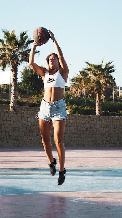 портрет баскетболистки, прыгающей с мячом - баскетбольная фотосессия