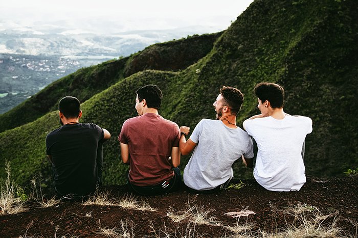 Четыре друга сидят среди красивого горного пейзажа - портреты в стиле lifestyle