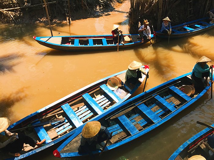 Снимок сверху людей, гребущих на деревянных лодках на реке - лучшее качество света для этого дня