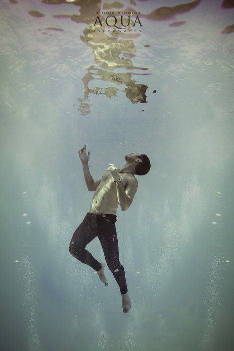 Атмосферная подводная фотосессия мужской модели, позирующей под водой
