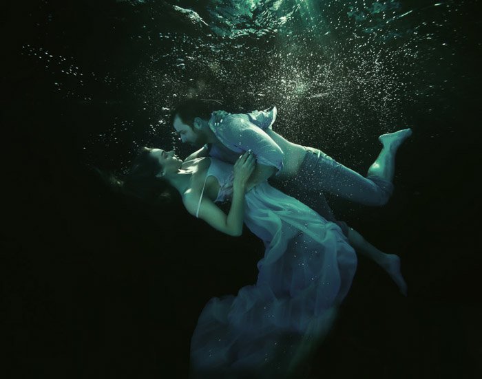 Атмосферная подводная фотосессия пары, обнимающейся под водой