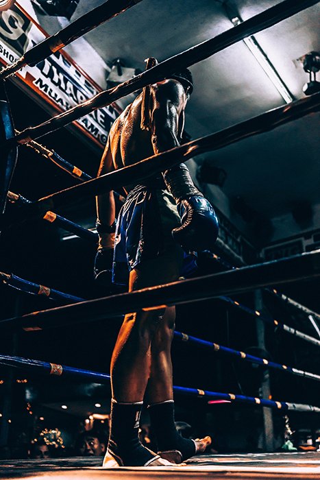 Атмосферная боксерская фотография бойца на ринге во время матча