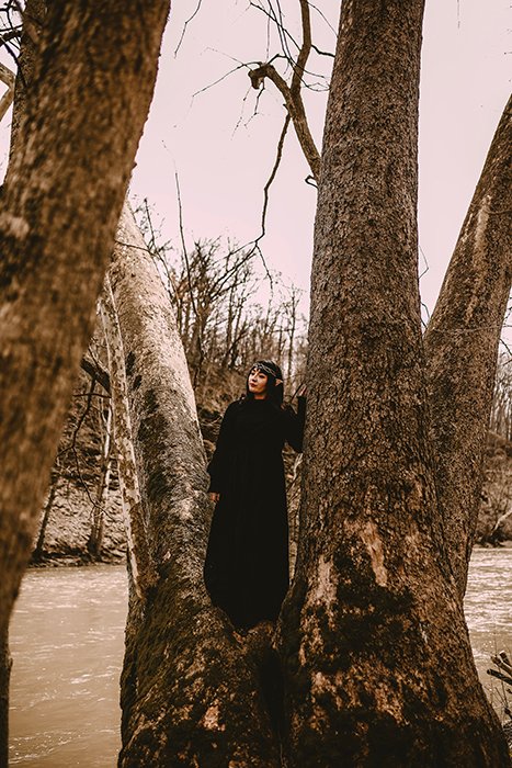 Косплей фотография женской модели в косплее эльфа, позирующей на дереве