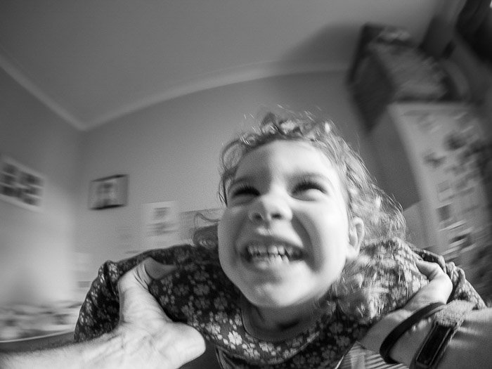 Черно-белый портрет улыбающегося ребенка, снятый объективом 