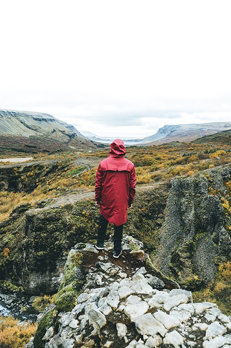 фотограф, стоящий на скале в горном ландшафте - места для фотографирования в Исландии