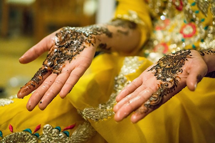 Красивый свадебный портрет украшенных рук индийской невесты, позирующей в традиционном костюме - индийская свадебная фотография