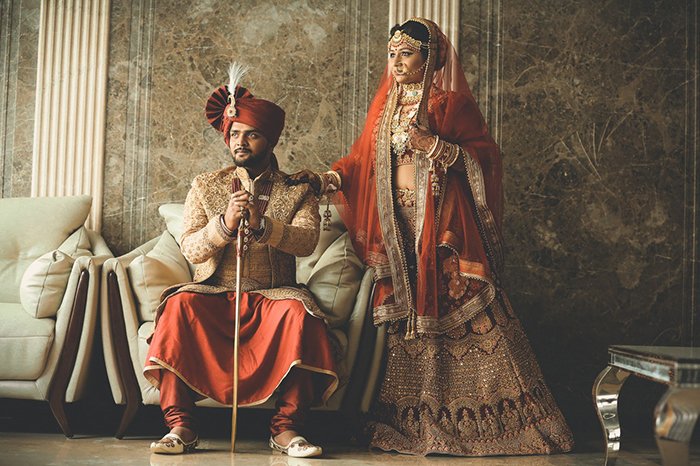 Красивый свадебный портрет индийской пары, позирующей в традиционном костюме