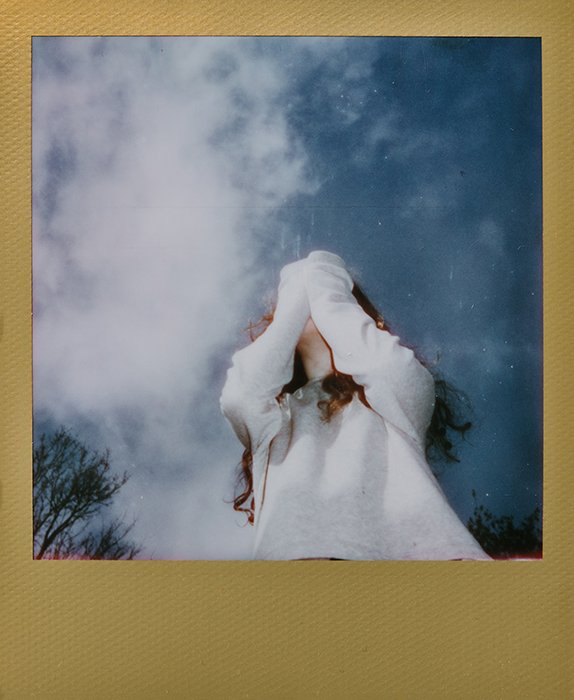 Dreamy instant photography portrait of the female model outdoors