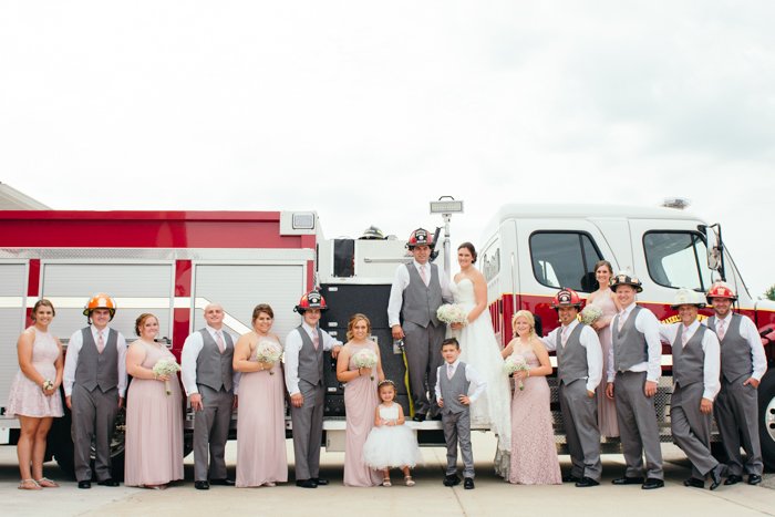 Свадебное групповое фото в касках пожарных у пожарной машины