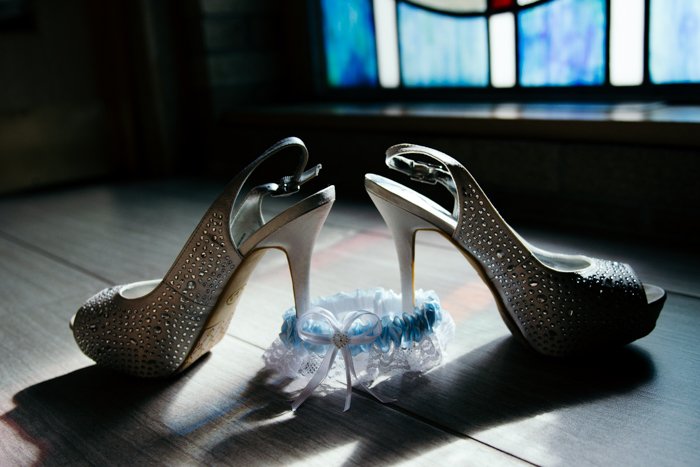 атмосферный натюрморт из свадебных туфель и подвязки на полу - советы по свадебной фотографии