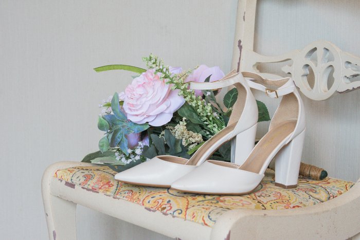 атмосферный натюрморт из свадебных туфель и цветов на стуле - советы по свадебной фотографии