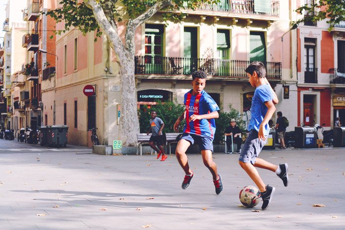 Футбольная фотография двух мальчиков, играющих в футбол на улице