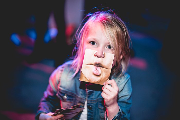 Смешной фотопортрет ребенка, держащего фотографию смешного рта к себе