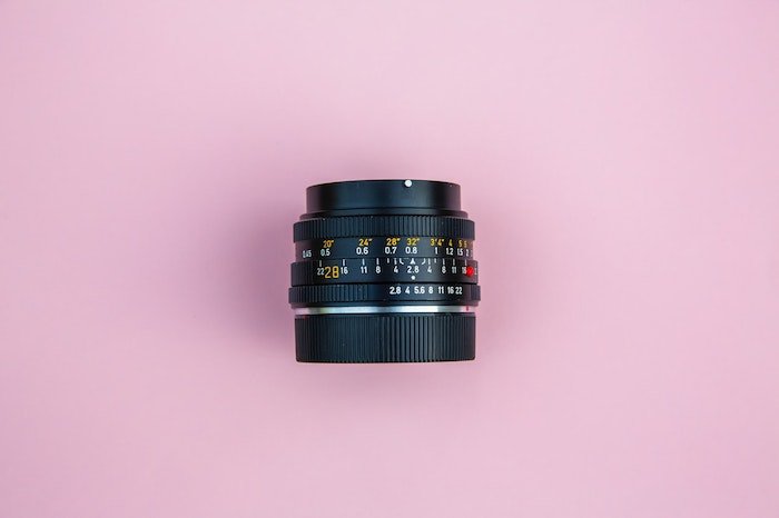 верхний снимок объектива камеры на розовом фоне - лучший объектив для фотографии товаров