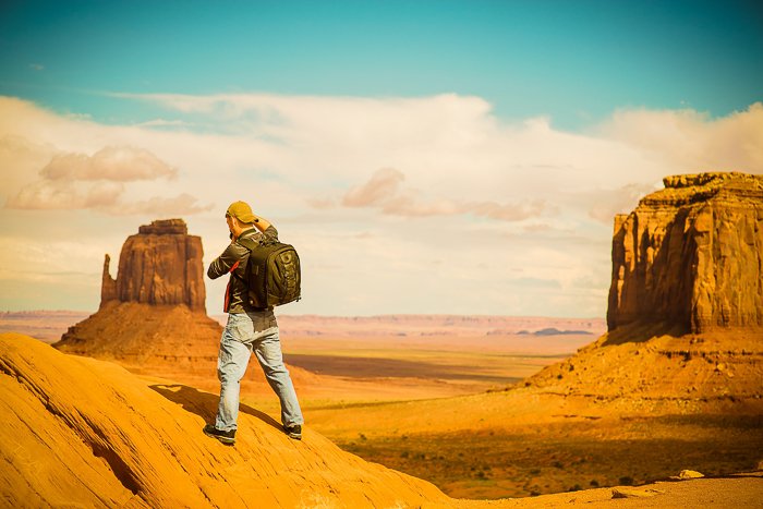 пеший турист стоит на скалистом пустынном ландшафте - навыки приключенческой фотографии