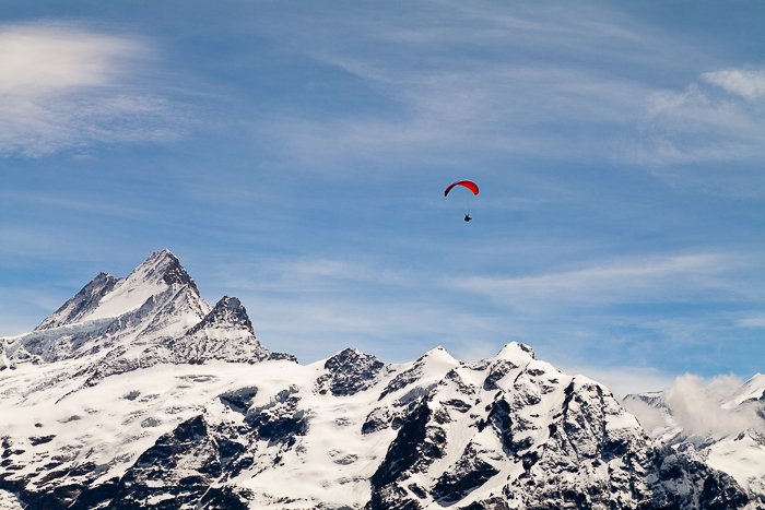 параплан, летящий над заснеженными горами - мастерство приключенческой фотографии