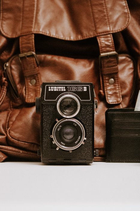 поиск руководств к фотоаппаратам онлайн: пленочный фотоаппарат lubitel 166 сидит перед коричневой кожаной сумкой