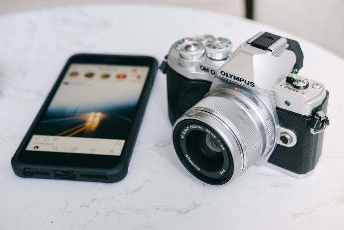 поиск руководств к фотоаппаратам онлайн: фотоаппарат olympus рядом со смартфоном на белом гранитном столе