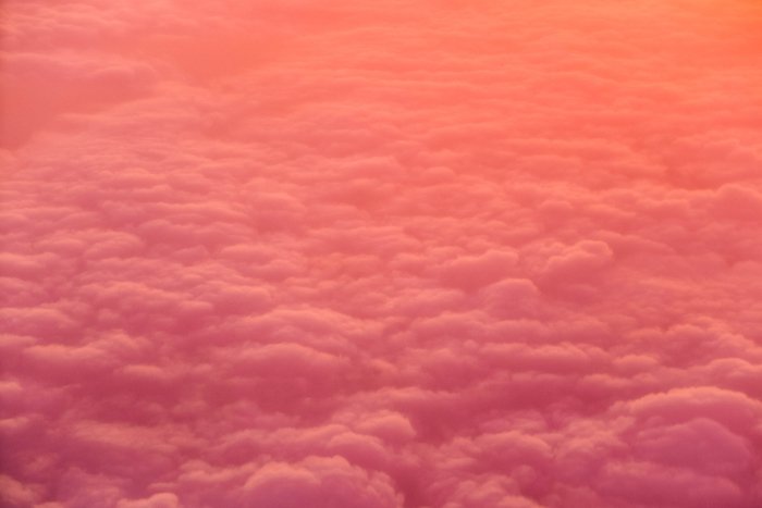 розово-оранжевая фотография облачного неба, снятая сверху