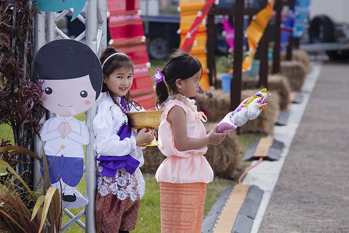 откровенное уличное фото двух маленьких девочек, держащих фестивальные предметы