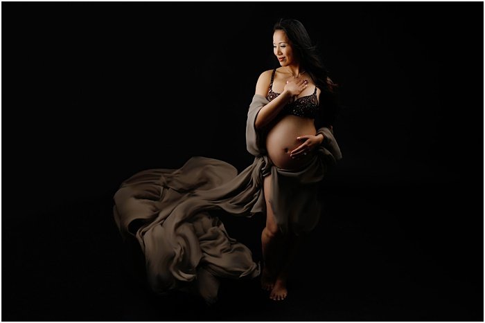 Фотография беременной женщины на фоне черного фона