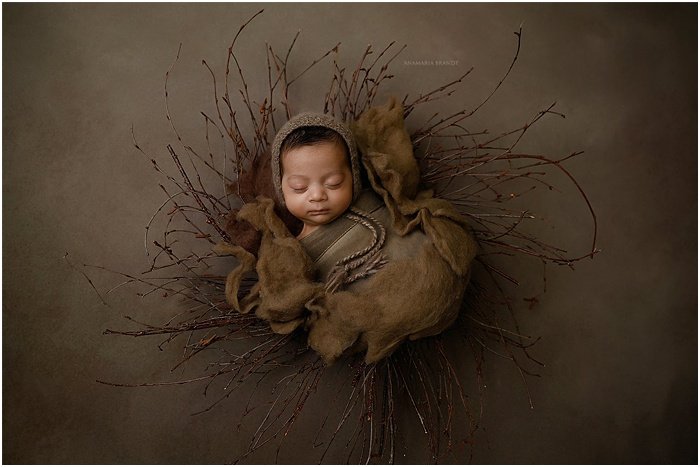 Художественное фото младенца на коричневом фоне