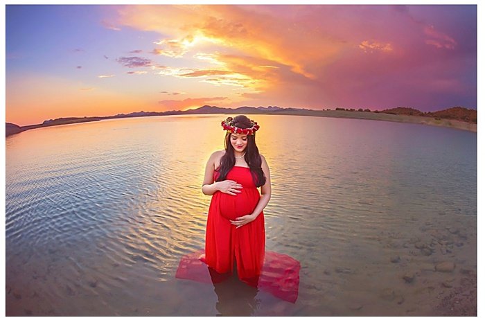 Фотография беременной женщины, стоящей в воде на закате