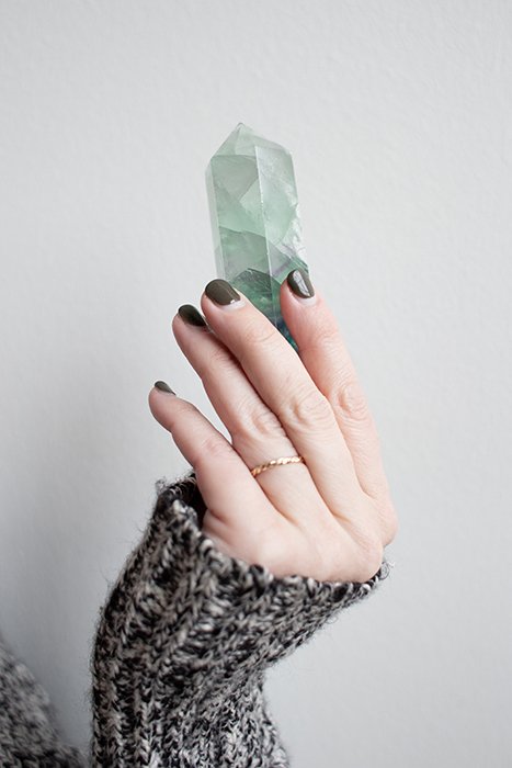 крутая фотография ногтей женщины-модели с накрашенными ногтями, держащей драгоценный камень