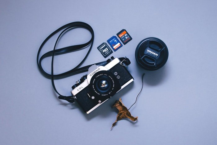 Фотография камеры и трех разных типов карт памяти