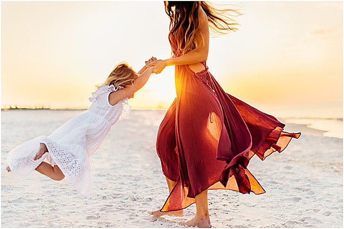 Фотография женщины, играющей с маленькой девочкой на пляже