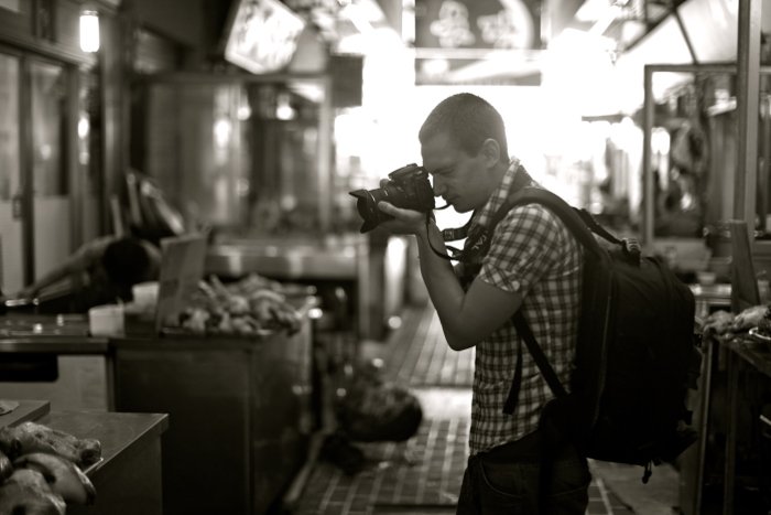 Фотограф с камерой и рюкзаком