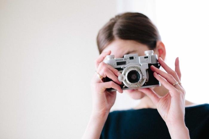 Женщина делает снимок цифровой камерой Kodak