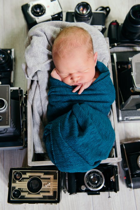 Фотография спящего младенца со старыми камерами вокруг него