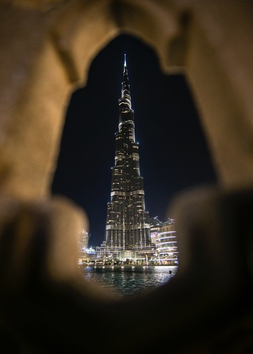 Тренд вертикальной фотографии: Фотография ночного небоскреба, сделанная через отверстие