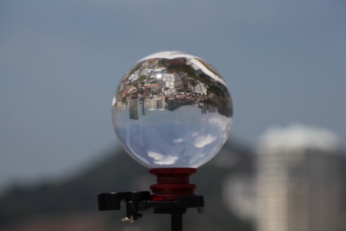 lensball на штативе, отражающий разрастающийся городской пейзаж